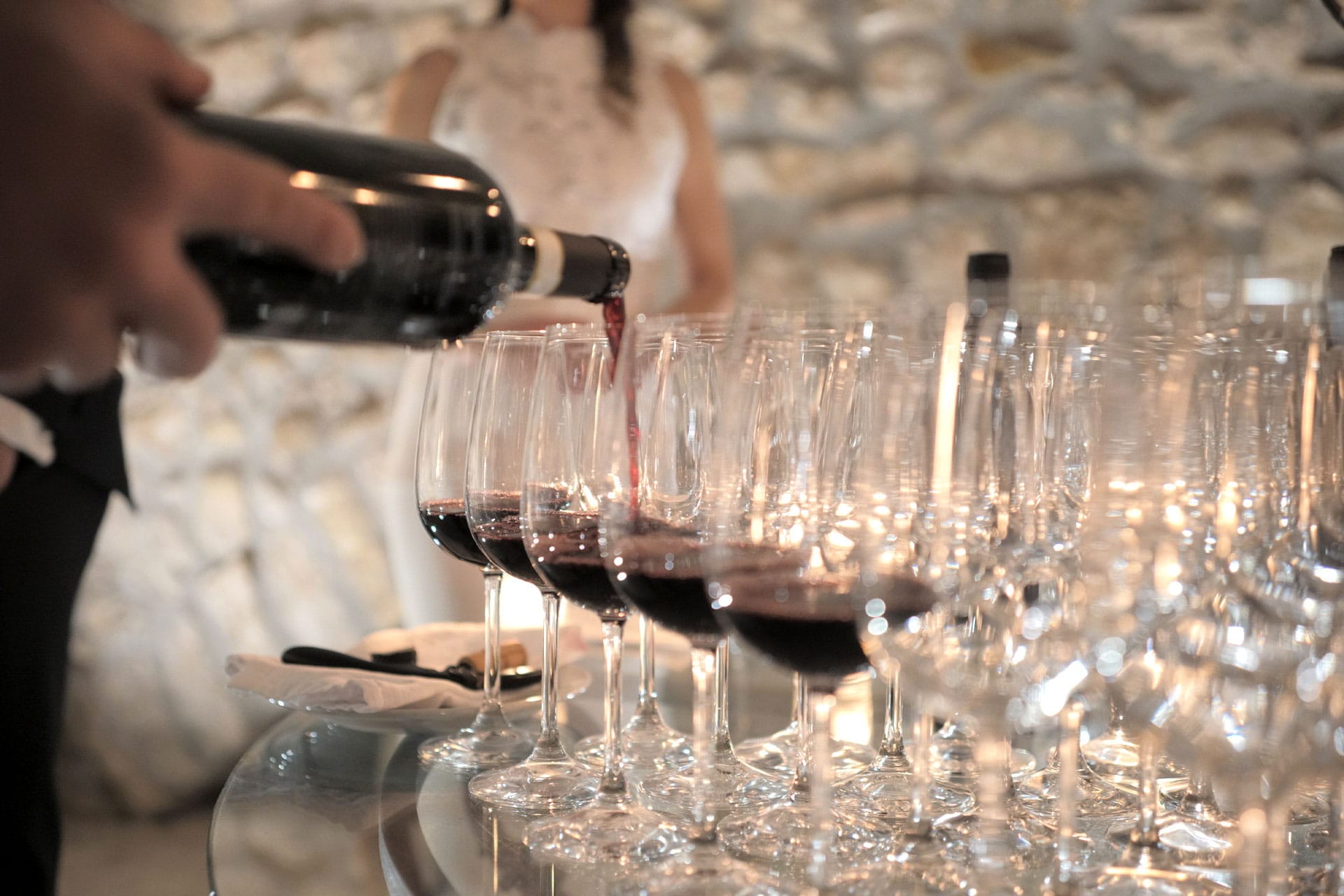 Calici di vino che vengono riempiti dal sommelier